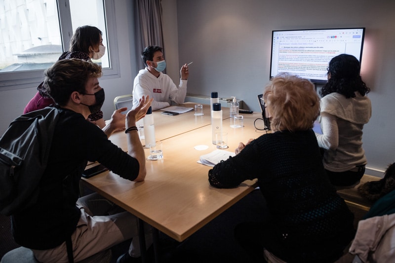 Conférence Citoyenne sur l'aide, l'entraide et les solidarités, 2021 - 5 participants travaillent et échangent, ils sont assis autour d'une table et ils consultent un écran