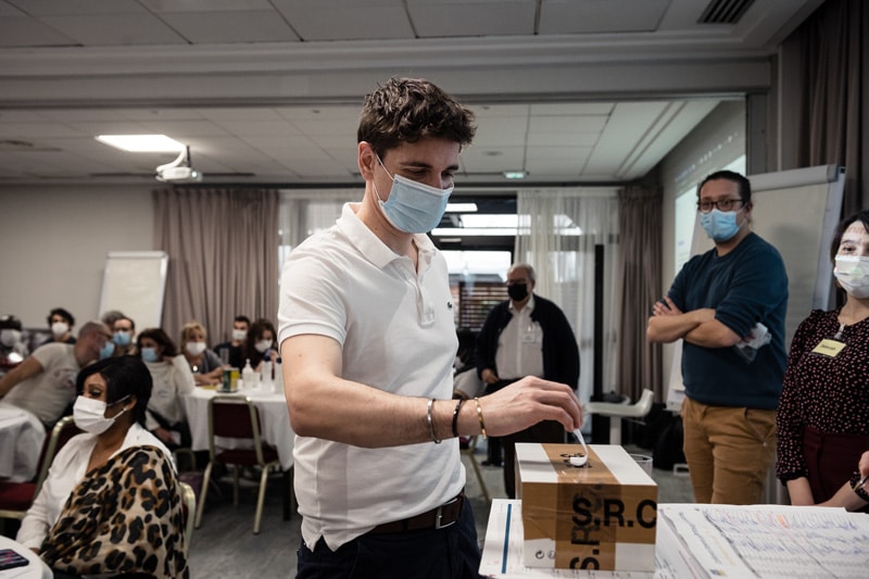 Conférence Citoyenne sur l'aide, l'entraide et les solidarités, 2021 - Un participant vote en glissant son bulletin dans une urne