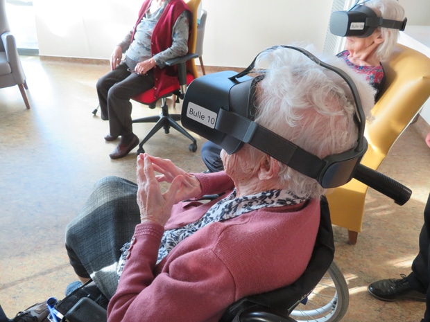 Des résidents en fauteuils se détendent avec un casque de réalité virtuelle