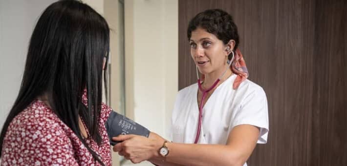 Centre de santé Roch à Montpellier : un médecin prend la tension d'une patiente avec un brassard lors d'une consultation.