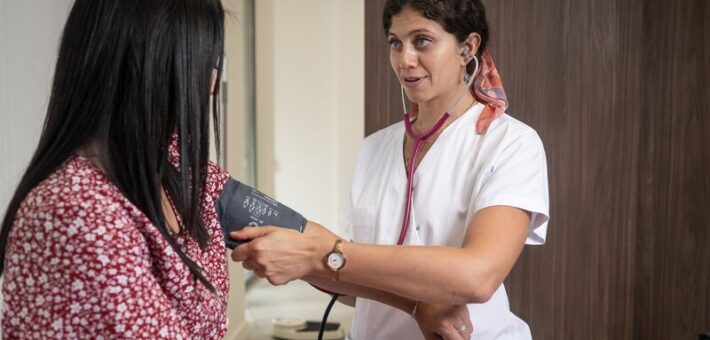 Centre de santé Roch à Montpellier : un médecin prend la tension d'une patiente avec un brassard lors d'une consultation